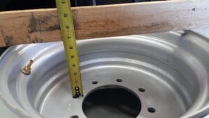 Skid steer tire rim offset showing tape measure