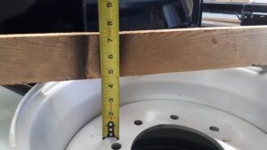 Skid steer tire rim offset showing tape measure