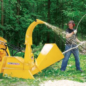 Skid steer mounting wood chipper chipping branches