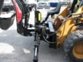 Skid steer back hoe with outriggers on a Case Skid Steer