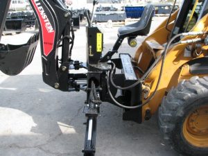 Skid steer back hoe with outriggers on a Case Skid Steer