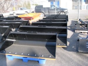 row of skid steer buckets on pallets