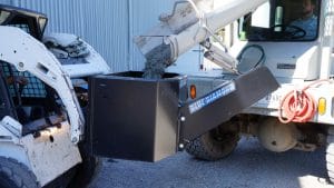 Concrete Dispensing Bucket 1/2 yard mounted on a skid steer being filled with fresh concrete