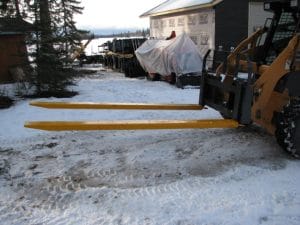 pallet fork extension mounted on skid steer pallet forks