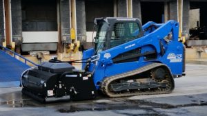 Blue Diamond Pick Up Broom with water kit mounted on blue tracked skid steer