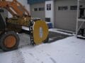 HLA snow pusher mounted on skid steer using back drag feature