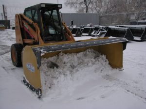 HLA snow pusher mounted on skid steer pushing snow