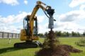 mini excavator with auger drive digging hole